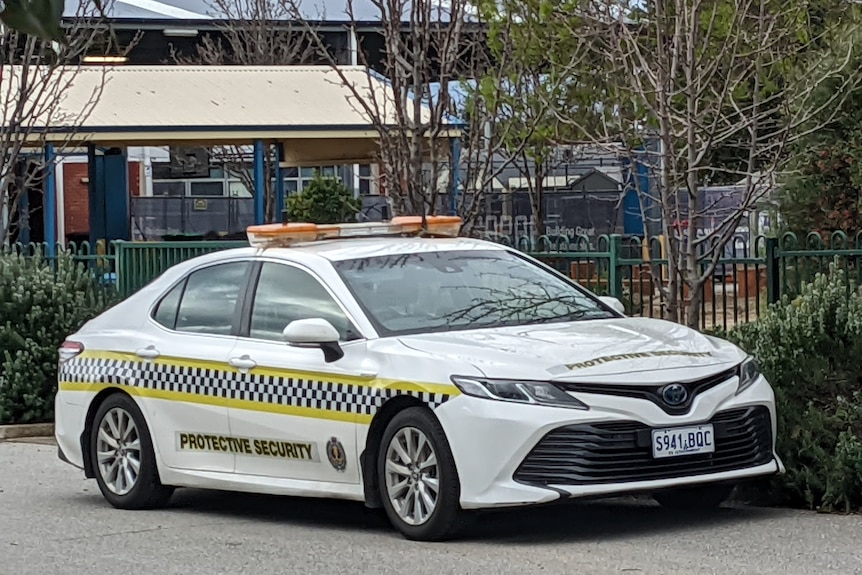 A protective security car outside school grounds