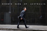 A businessman walks past the Reserve Bank of Australia in Sydney