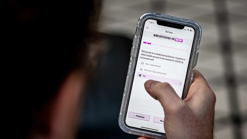A mobile phone screen displays an app that asks questions about COVID-19