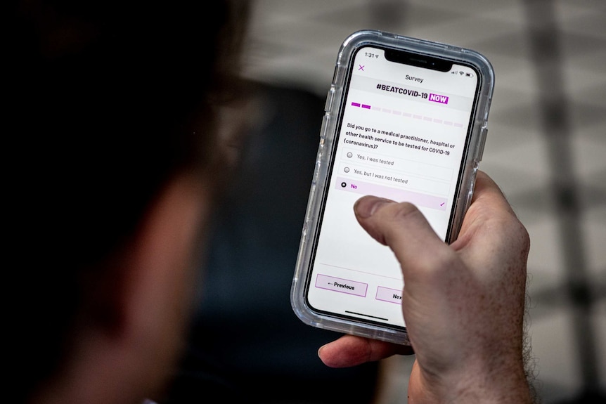 A mobile phone screen displays an app that asks questions about COVID-19