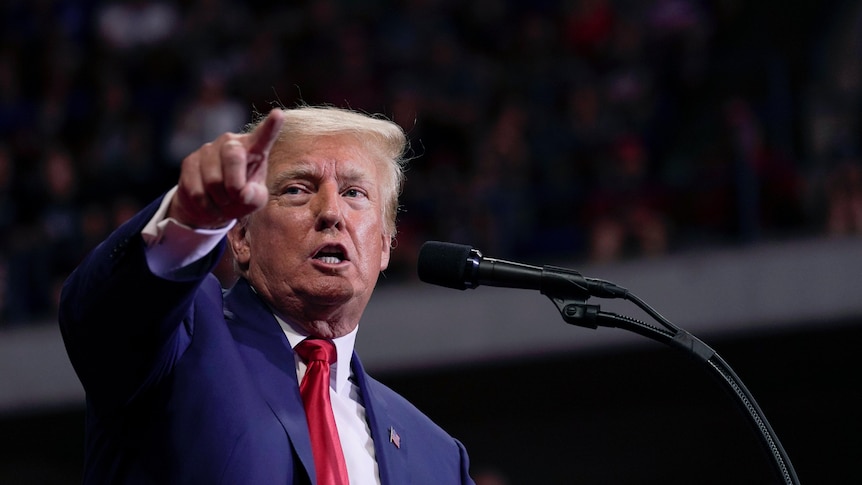 Former President Donald Trump speaks at a rally, pointing.