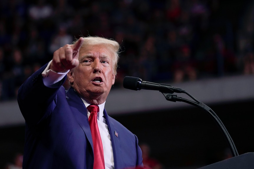 Former President Donald Trump speaks at a rally, pointing.