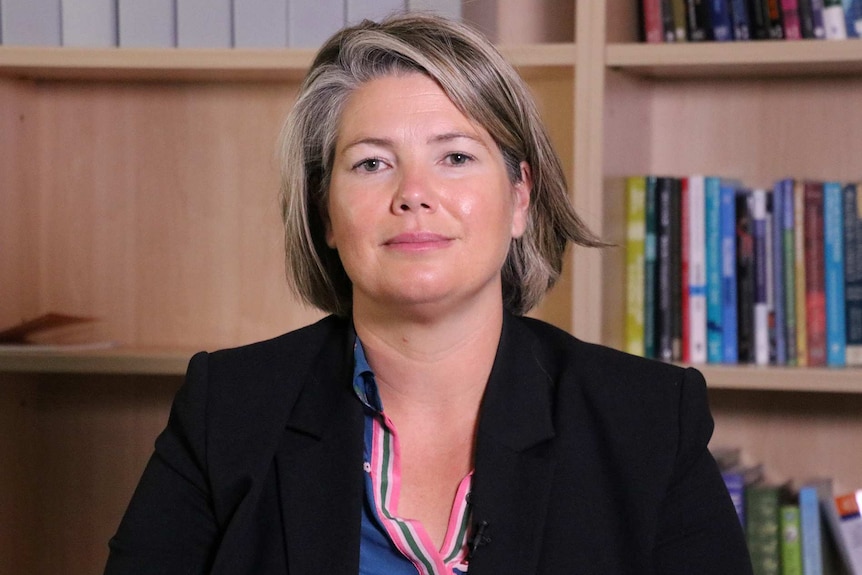 A head and shoulders shot of Professor Amanda Davies posing for a photo in an office in front of a bookcase.