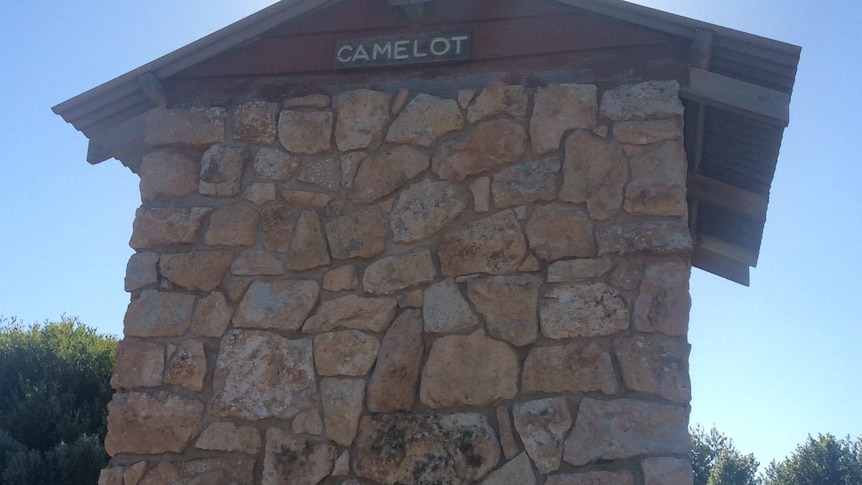 Small stone building with air vent and word Camelot written on it