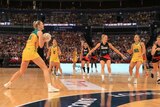 An Australian netballer shapes to pass the ball as she stands outside the two-point shot line.