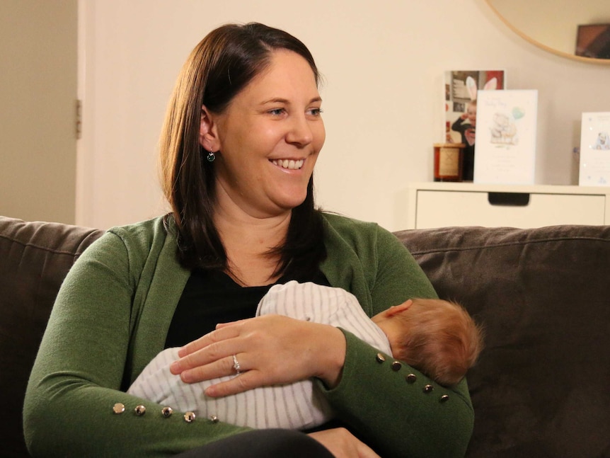 A mum cradles a little newborn baby boy.