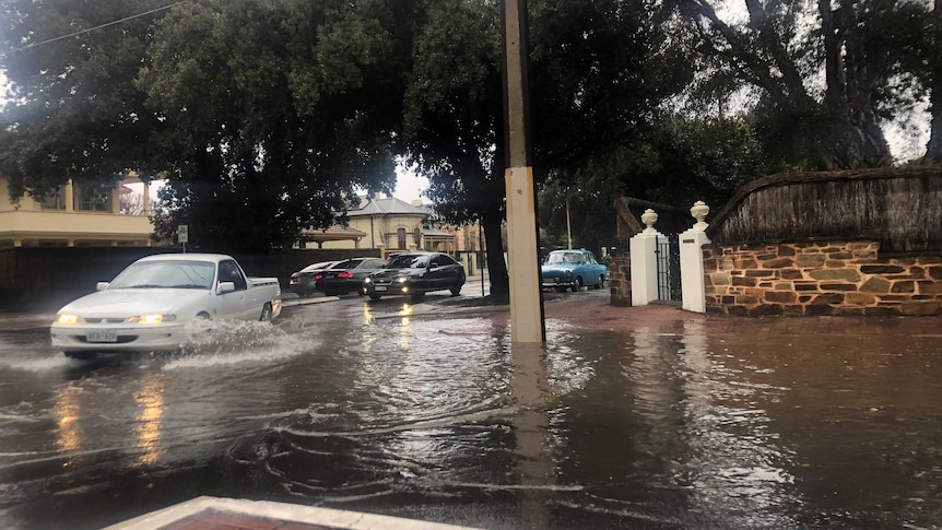 A flooded street with cars going through