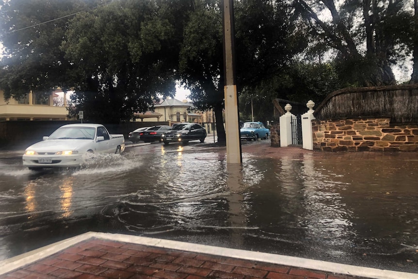 A flooded street with cars going through