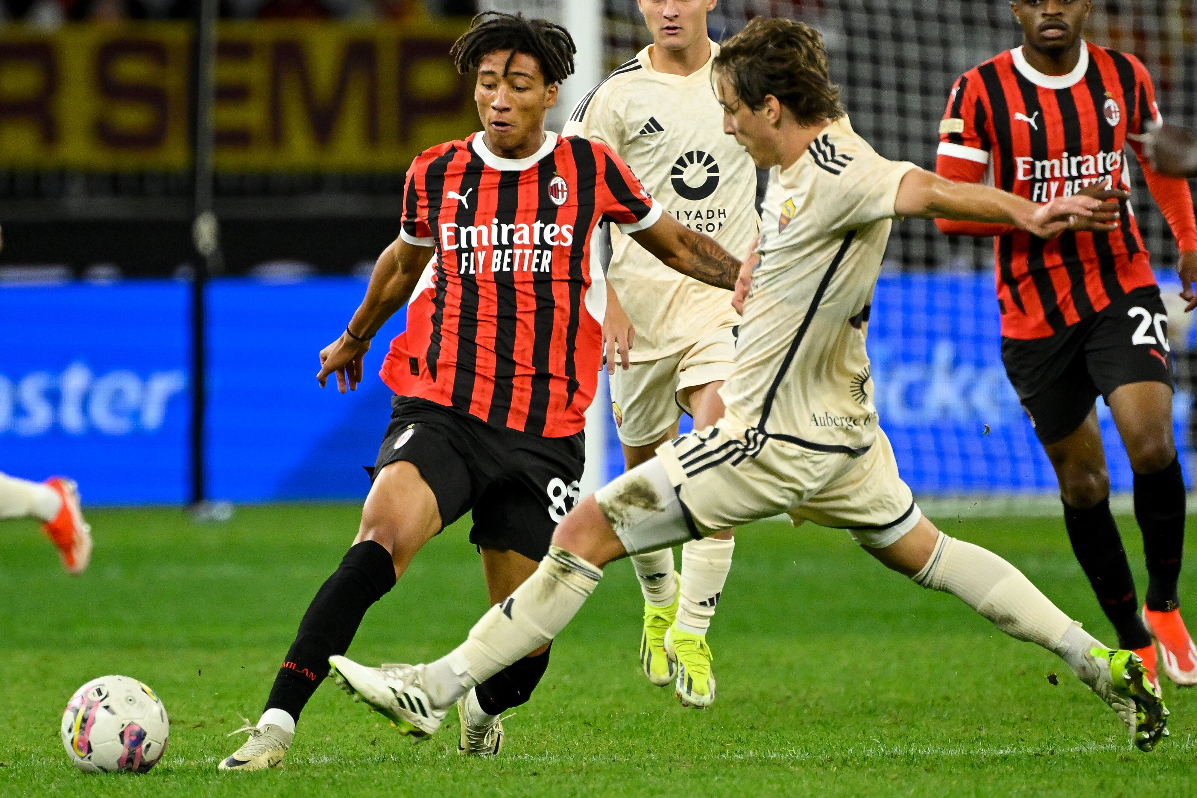 An AC Milan footballer is tackled by another player. 