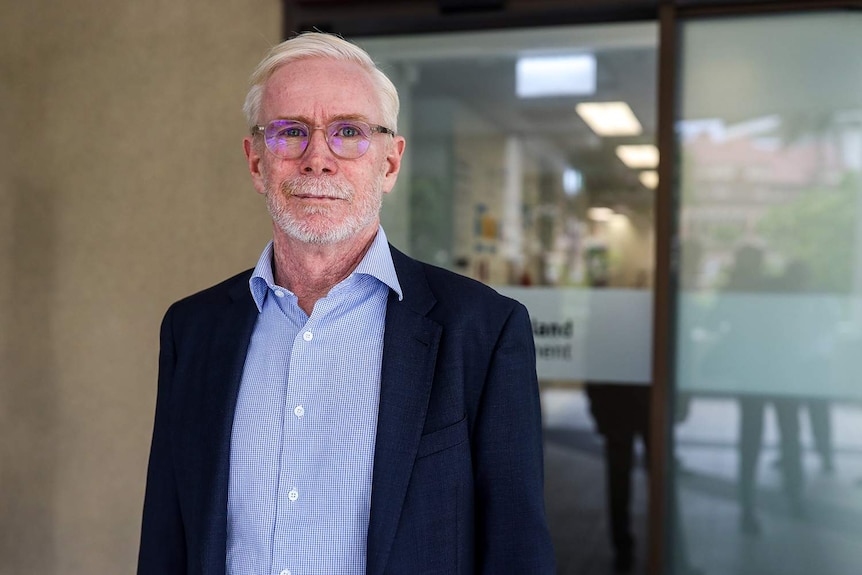 Malcolm Letts stands in front of a building in Brisbane