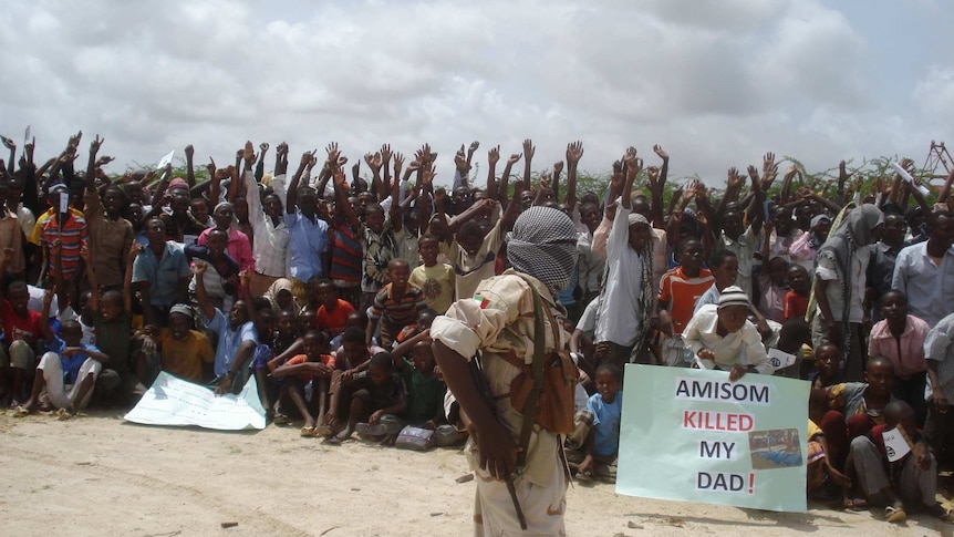 Somali men carry weapons during an demonstration organised by Al-Shabaab