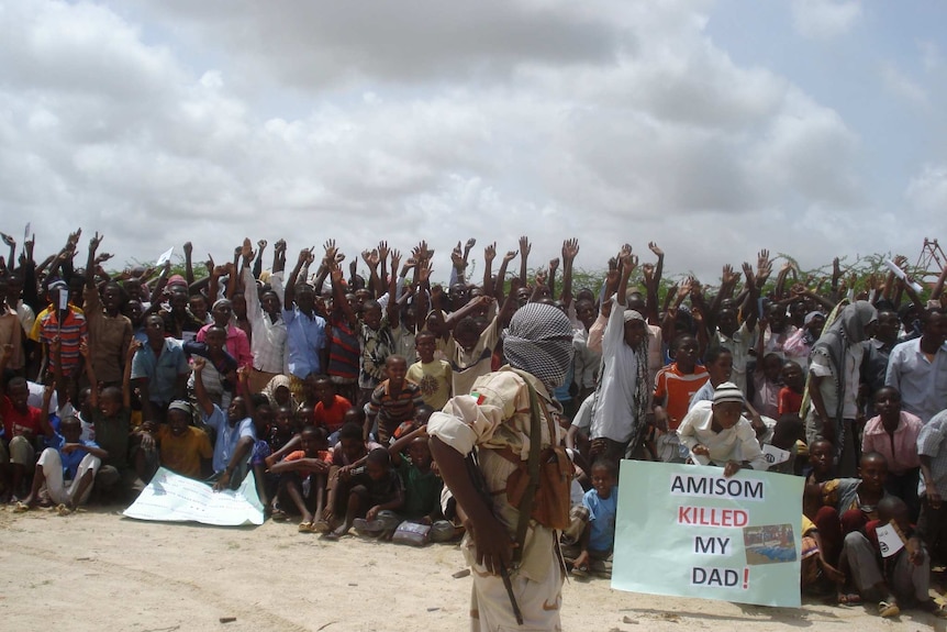 Somali men carry weapons during an demonstration organised by Al-Shabaab