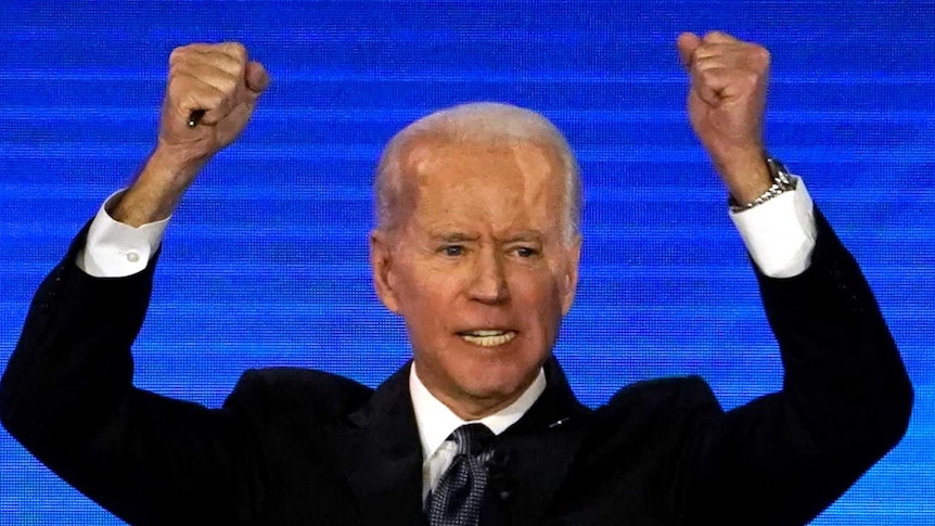 Democratic 2020 US presidential candidate former Vice President Joe Biden raises his hands