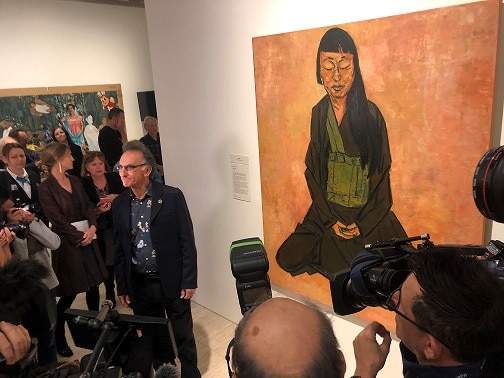 Tony Costa poses with his portrait of Lindy Lin after winning the Archibald Prize.