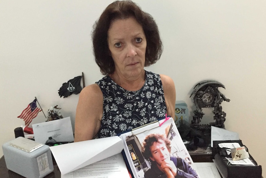 Sue Jenkins holds a petition and a photo of her son Dann Jenkins.
