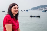 A woman in a red dress gazes over the water in Vietnam