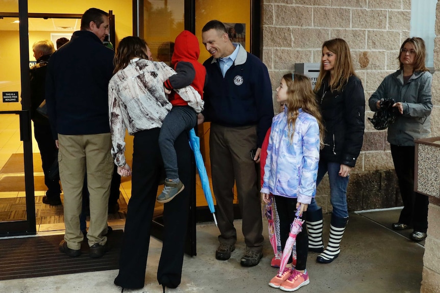 Republican Scott Perry stands in line and greets voters with withe children in Pennsylvania during US midterm elections.