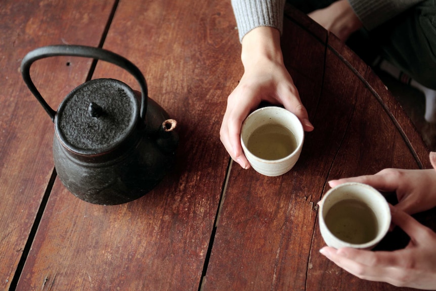 Two people share a cup of tea