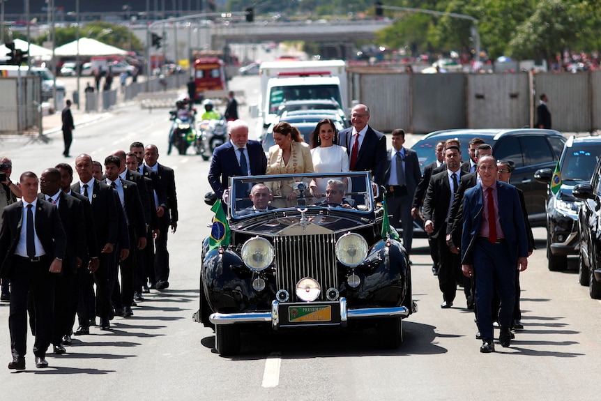 The motorcade of Brazil's President elect Luiz Inacio Lula da Silva with security lining either side.
