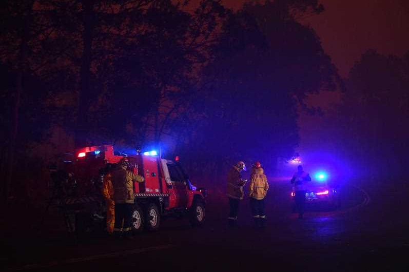 Fire crews in the darkness at a roadblock.