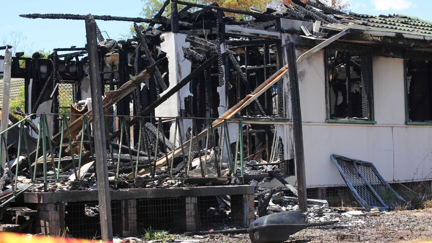 A home gutted by fire with yellow NSW fire services tape across the front