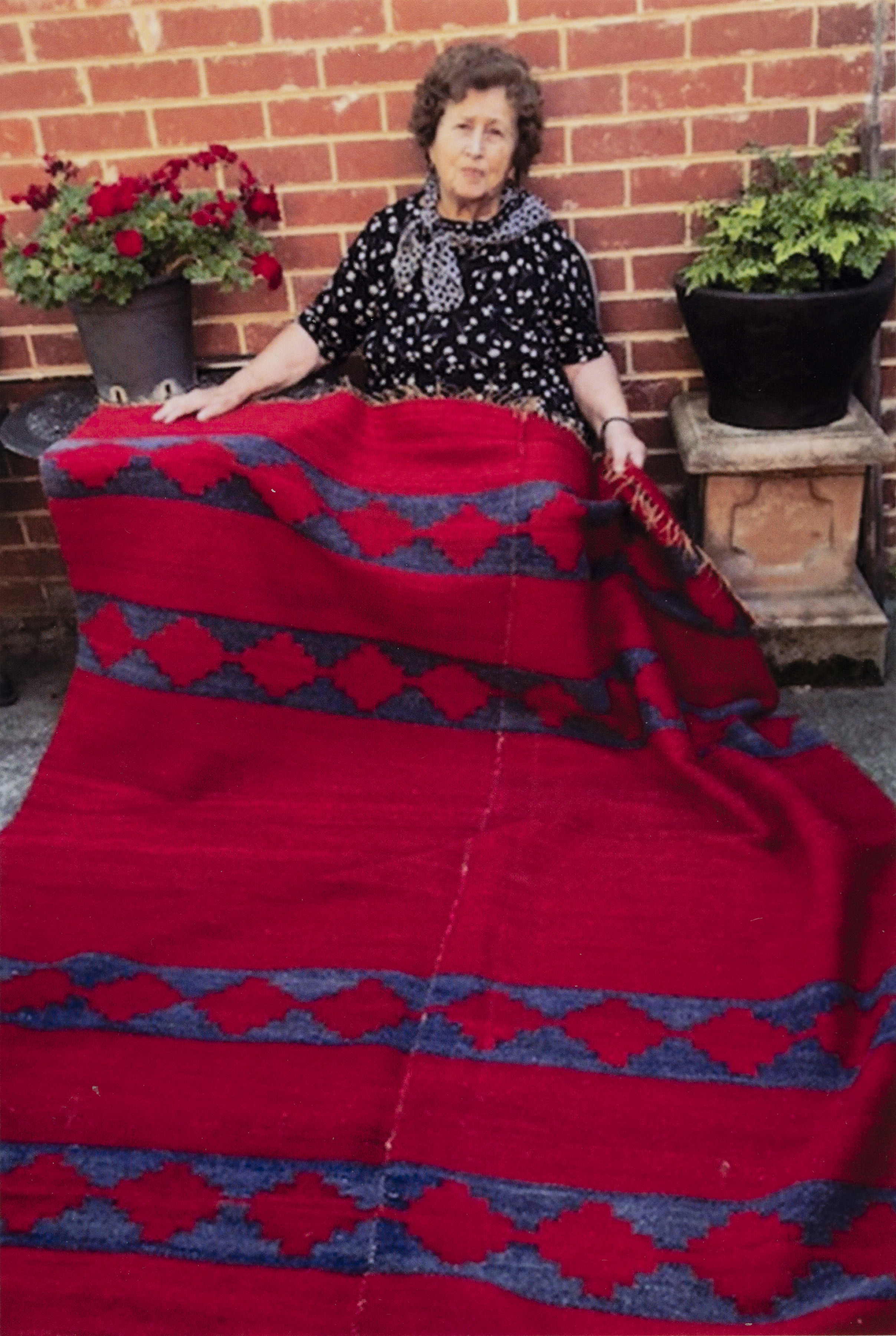 A woman holding a red and blue blanket