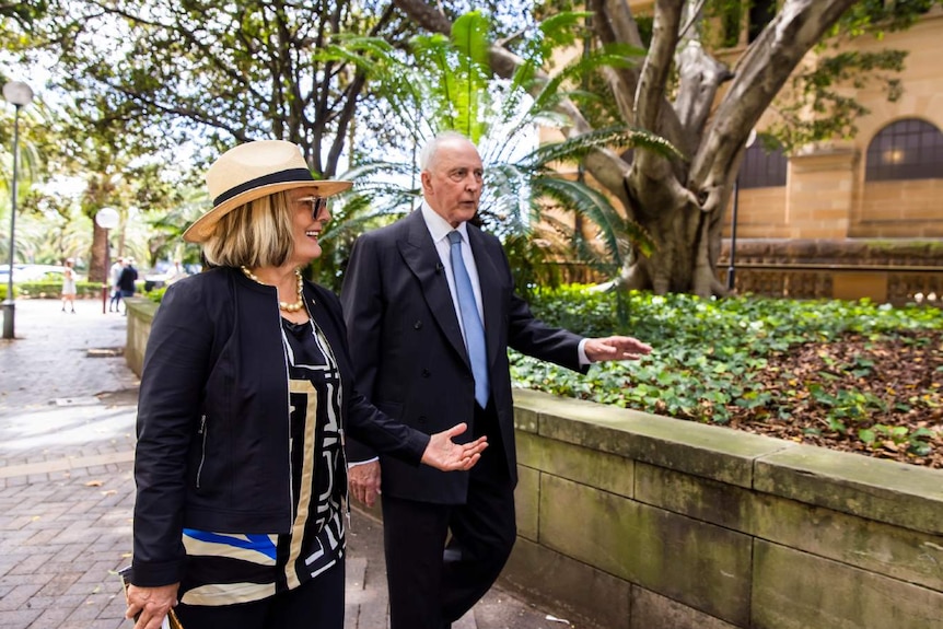 A man and woman walk outside