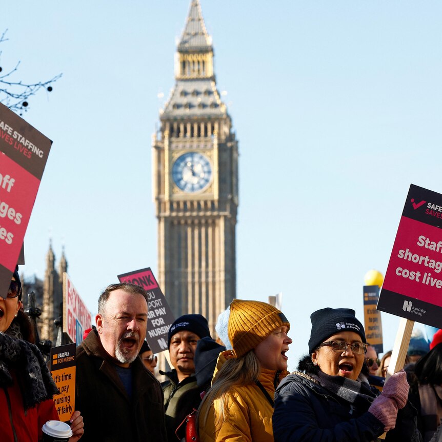 A group of protesters holding placards which read "staff shortages cost lives" with big ben clock tower in the background