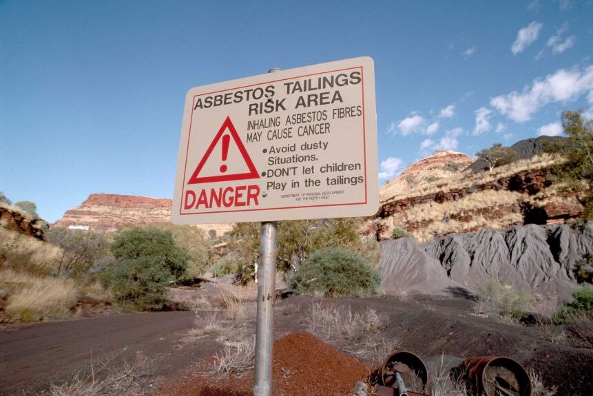 A sign warns of the dangers posed by asbestos tailings.