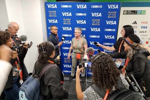 Varios periodistas se reúnen para una conferencia de prensa, una persona se encuentra frente a un fondo azul para una entrevista