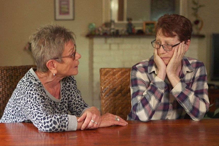 Lynda Henderson and Veda Meneghetti talk at a table