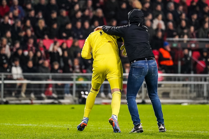 Marko Dmitrovic is attacked by a fan from behind