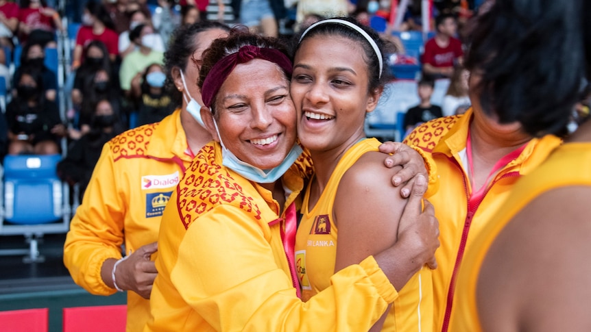 Two Sri Lanka players hug each other after the netball game while on court.