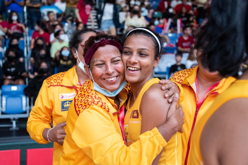 Two Sri Lanka players hug each other after the netball game while on court.