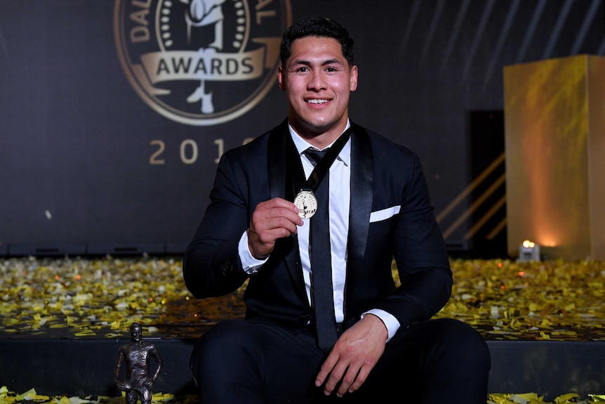 Roger Tuivasa-Sheck sits for photographers as he holds the Dally M Medal.