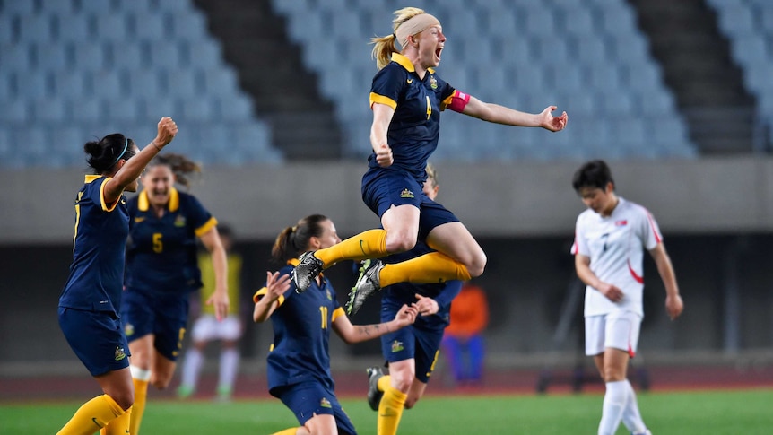Clare Polkinghorne (top) celebrates Matildas' qualification for Olympics with win over Nth Korea.