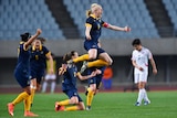 Clare Polkinghorne (top) celebrates Matildas' qualification for Olympics with win over Nth Korea.
