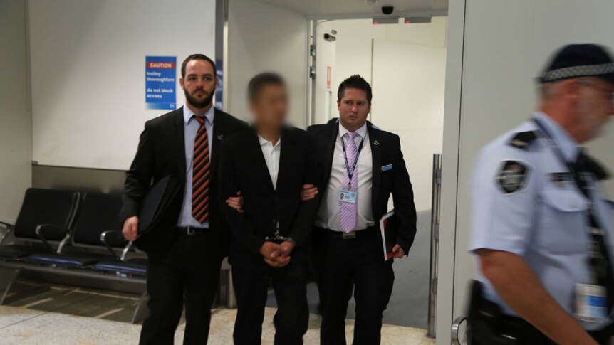 A man is arrested at Sydney Airport over the discovery of another man's body found in a car boot at Lidcombe.