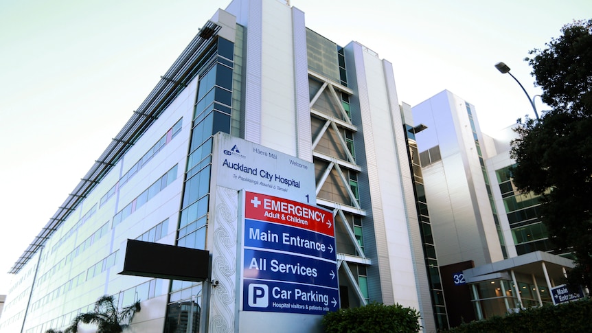 The outside of a large building with a sign that says Auckland City Hospital.