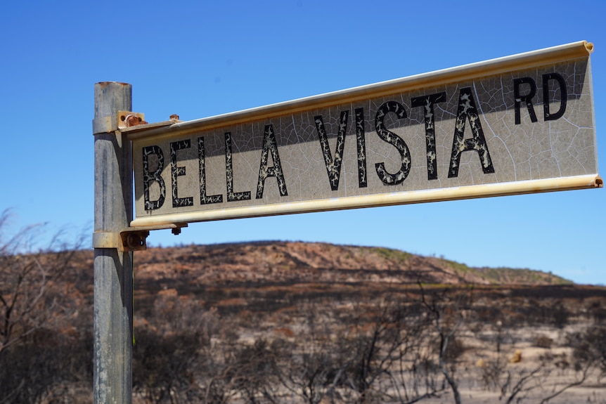 A burnt sign says bella vista road. the background is burnt. 
