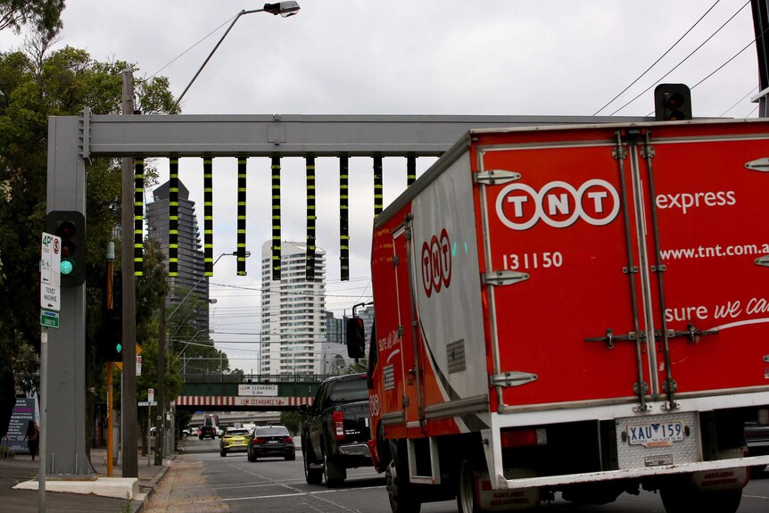 A truck approaching the height warning gantry before the Montague St bridge in Melbourne.