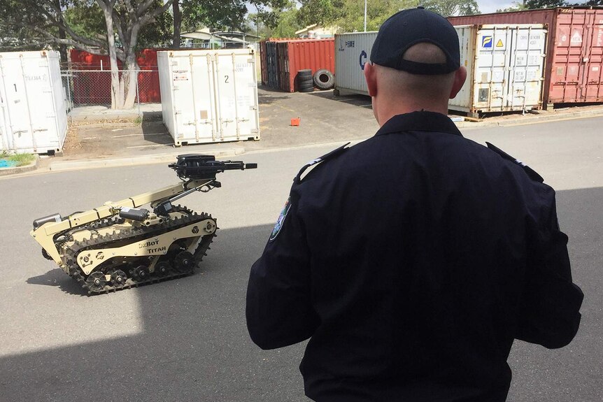 A Queensland police officer operates the OzBot Titan robot