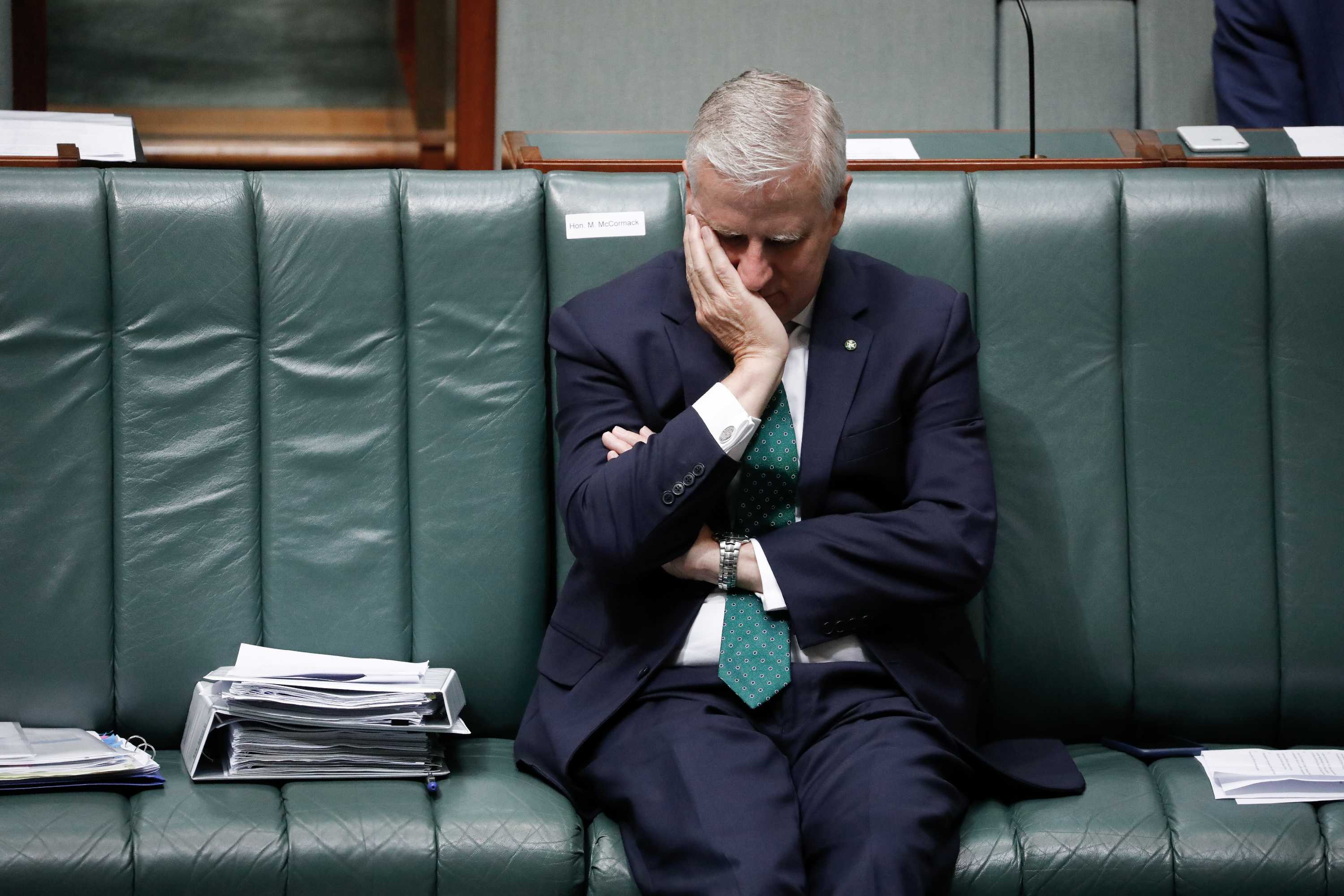 McCormack puts face into hand whilst sitting down on frontbench.