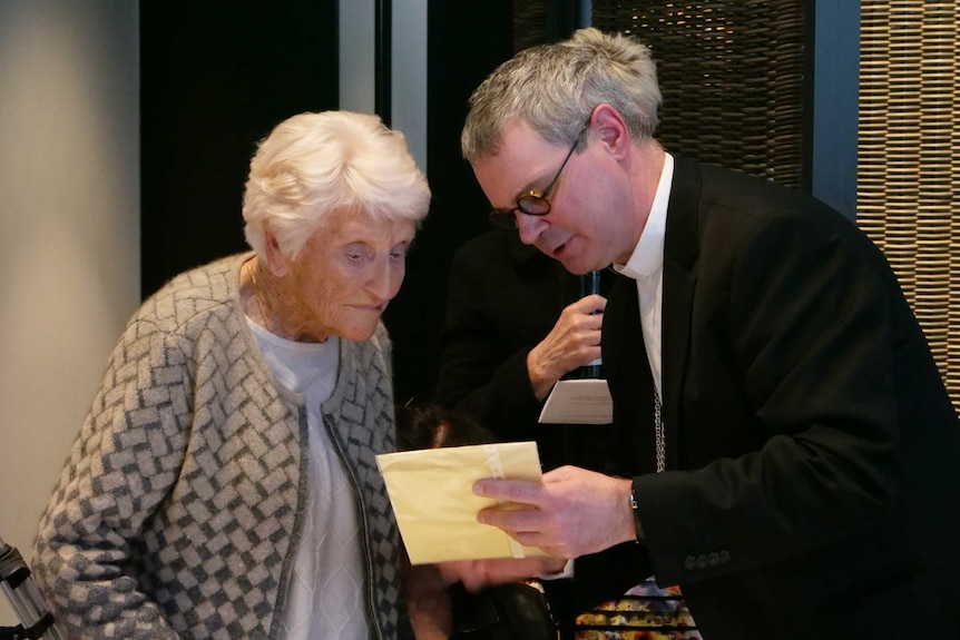 Eileen Piper showing Peter Comensoli a photo of her dead daughter.