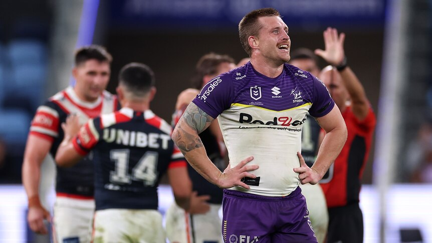 Melbourne Storm's Cameron Munster looks up at the big screen with hands on hips after being sin-binned.