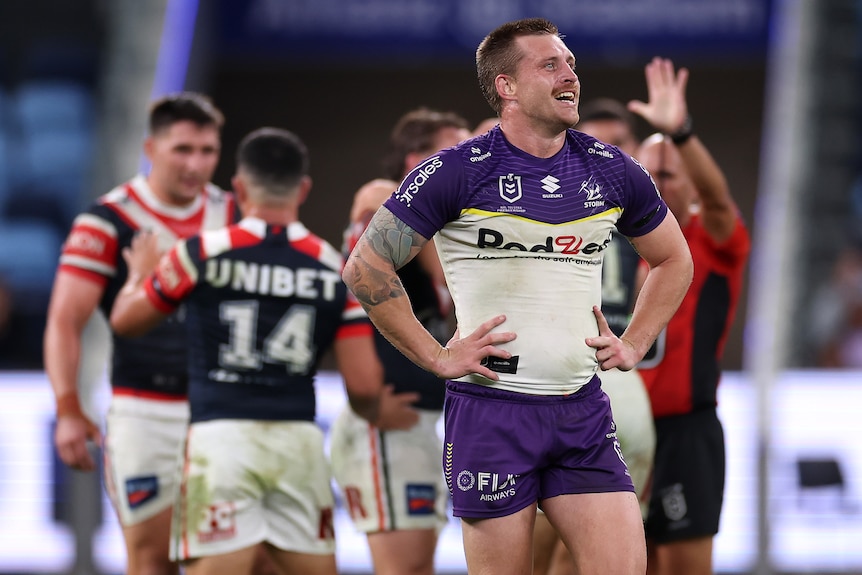 Melbourne Storm's Cameron Munster looks up at the big screen with hands on hips after being sin-binned.