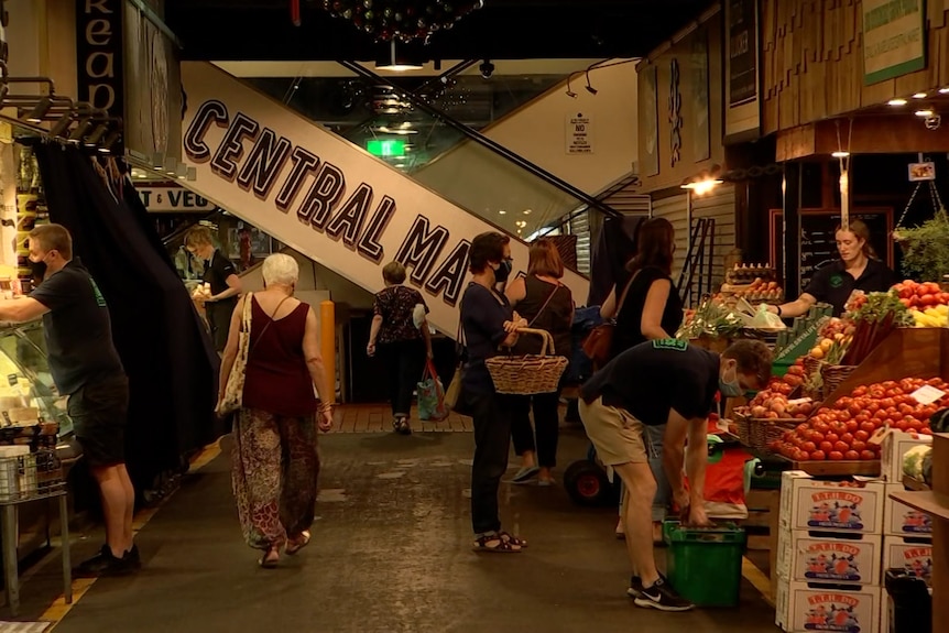 An indoor food market with an escalator in the background saying CENTRAL MA...