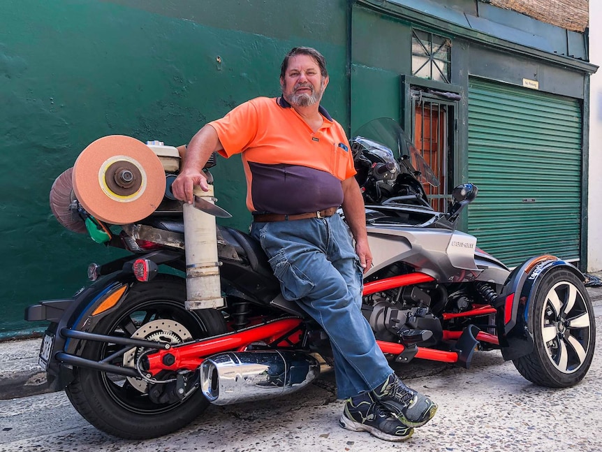 Mobile knife sharpener Terry Smith with his three-wheeled motorbike.