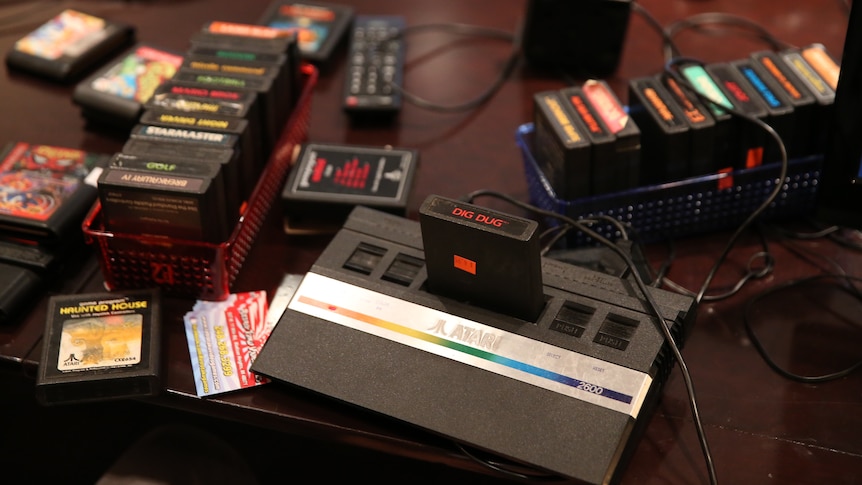 An Atari 2600 video game console surrounded by many games.