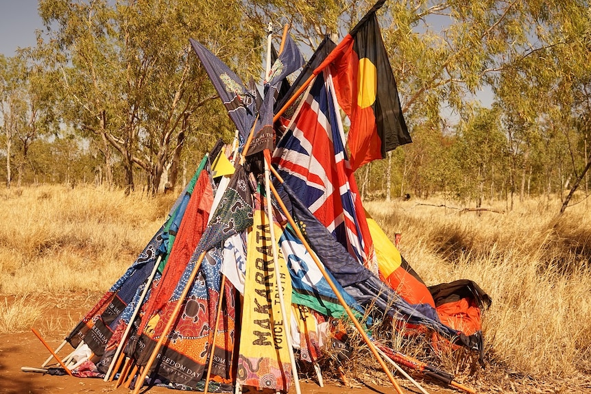 A cluster of Aboriginal flags forms a pyramid